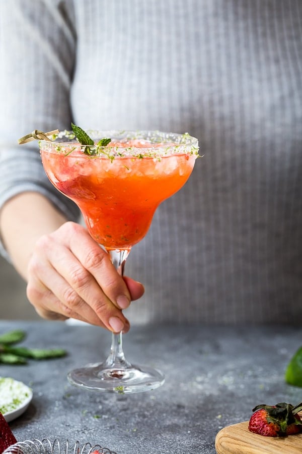 A woman is serving Mexican Champagne Cocktail photographed from the front view