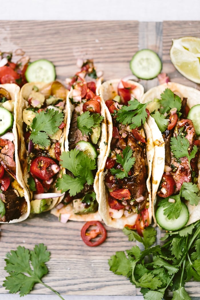 Recipe for Grilled Flank Steak Tacos with a foolproof flank steak marinade placed on a cutting boards 