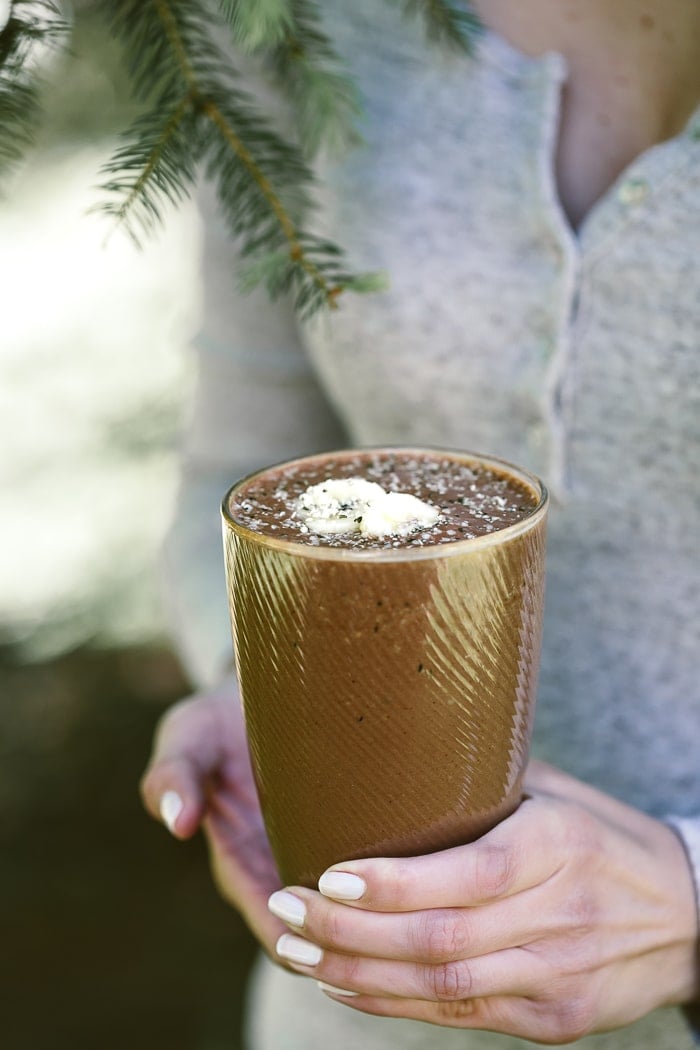 A person holding a banana split smoothie