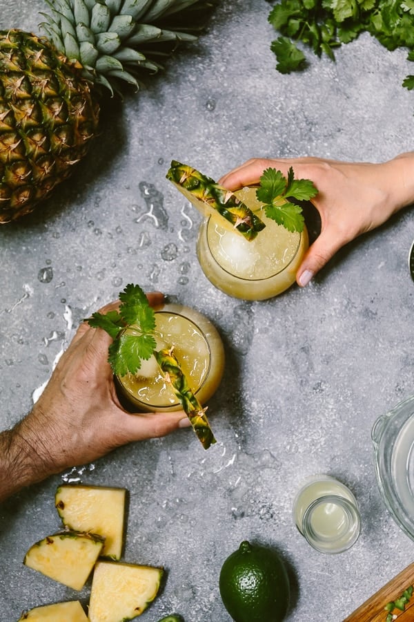 two people are about to grab mezcal pineapple jalapeno cocktail