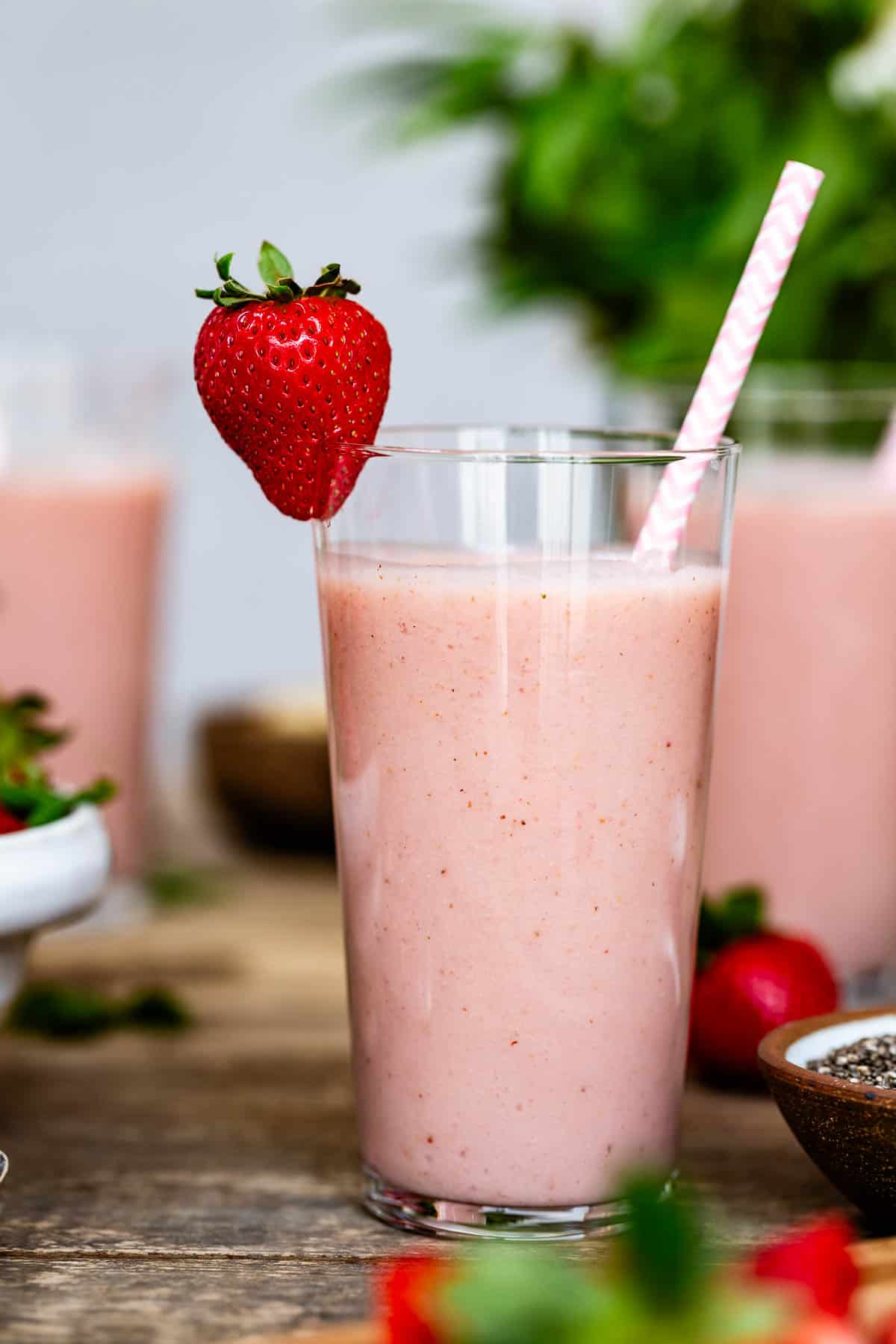 Strawberry banana smoothie in a glass garnished with a strawberry.