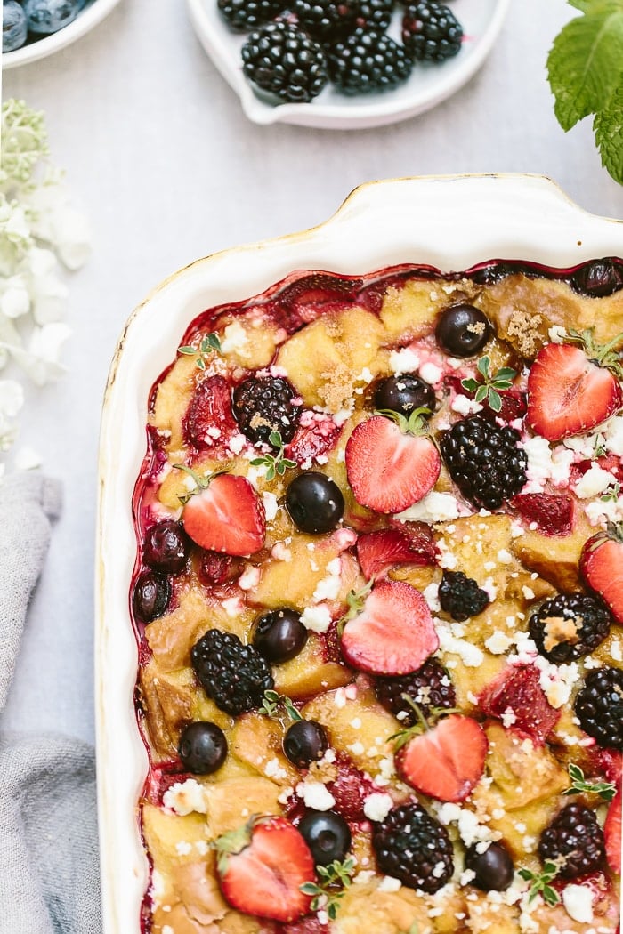 Mixed berry bread pudding with goat cheese is in a casserole dish from the top view.