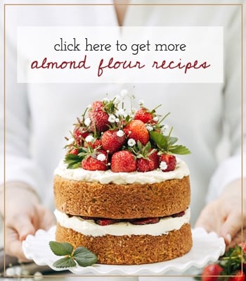 A woman is serving a strawberry cake