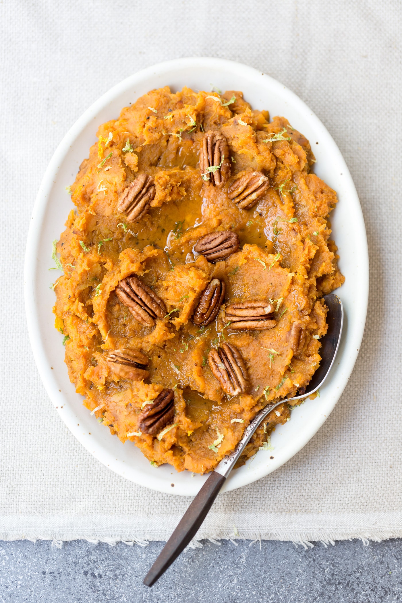 Maple sweetened mashed sweet potato recipe topped off with pecans and more maple syrup