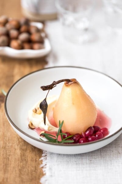 A bowl of cranberry poached pears served with mascarpone and hazelnuts