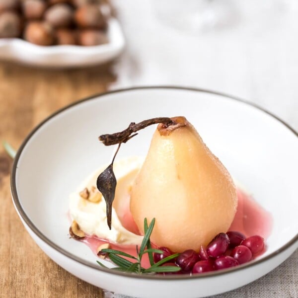 A bowl of cranberry poached pears served with mascarpone and hazelnuts