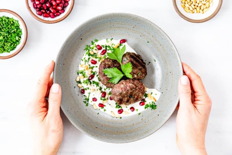 Turkish beef meatballs in a plate garnished with fresh parsley.