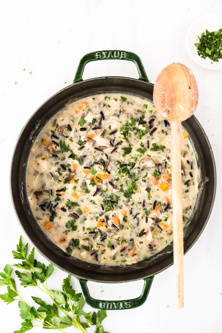 A big pot of Lightened-Up Creamy Chicken and Wild Rice Soup is photographed from the top view.
