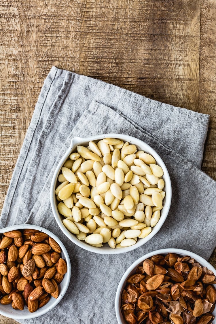 Almonds with the skin on and skin off. Plus the peels are in a bowl photographed from the top.