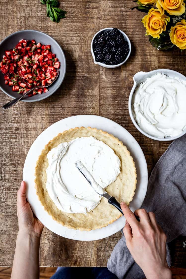 Strawberry Tart with Mascarpone Cheese made with almond flour tart crust being spread with mascarpone cream from the top