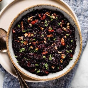 Black rice placed in a bowl with a spoon on the side