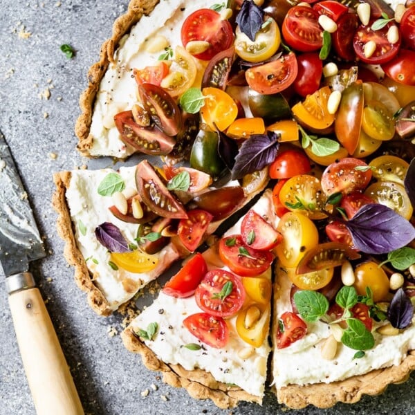 Tomato Ricotta Tart sliced and photographed with a knife on the side