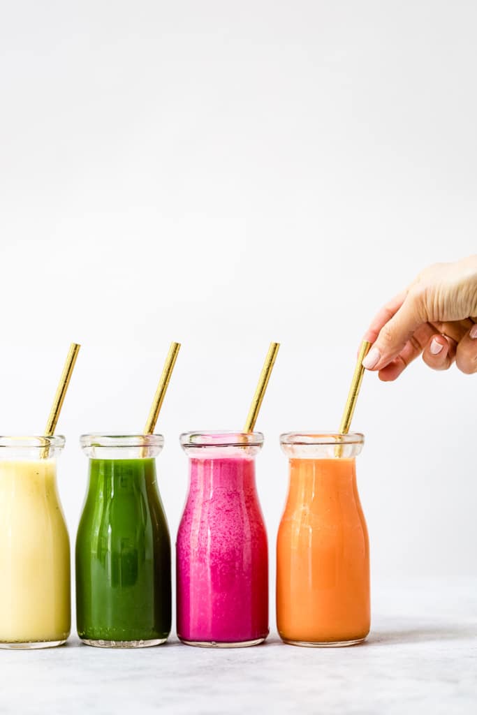 A ground Superfood Smoothies with a straw in each out them
