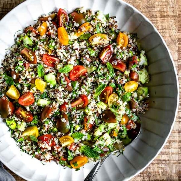 A big bowl of Quinoa Tabbouleh Salad with a spoon on the side