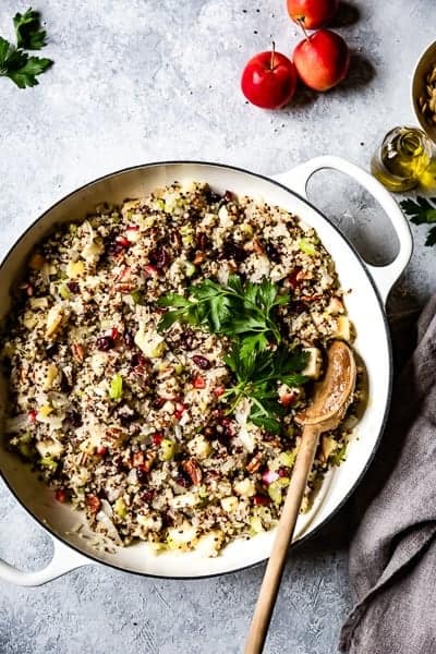 Quinoa, apple and cranberry stuffing for the best vegan stuffed acorn squash recipe in a large skillet from the top view