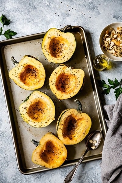vegan stuffed squash - Acorn squash is placed on a sheet pan to be roasted