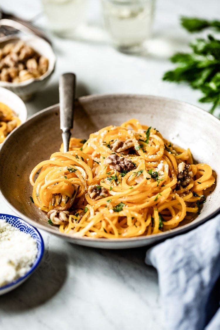 sauteed butternut squash noodles in a large bowl from the front with a fork in the bowl