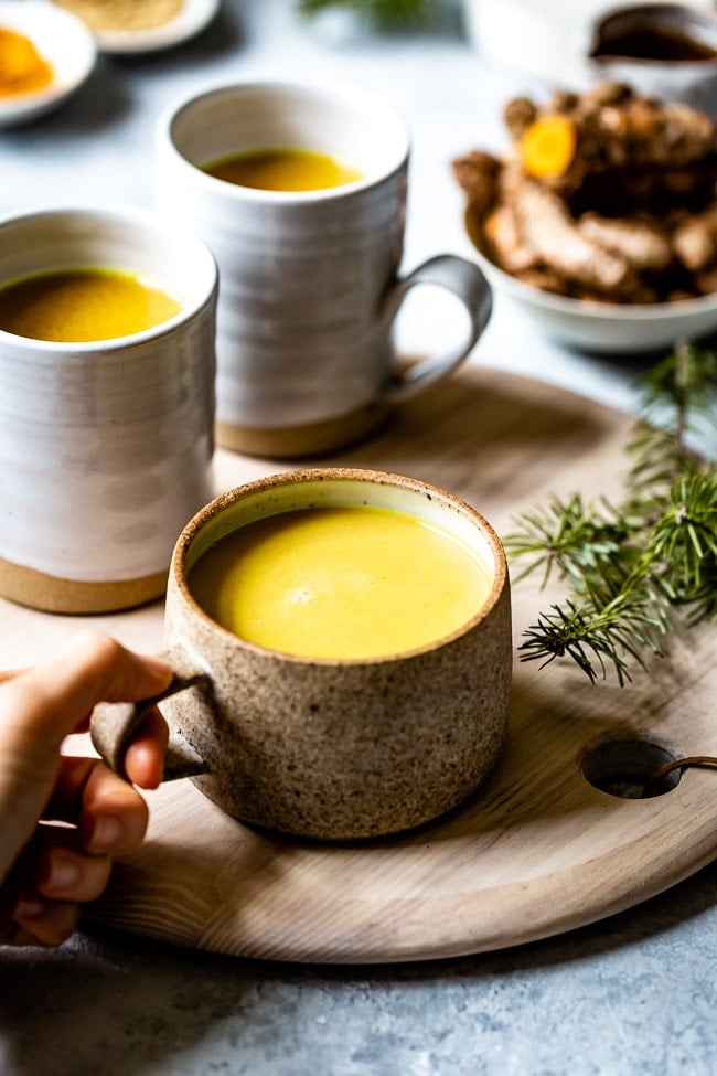 A big mug of turmeric golden milk recipe photographed from the front view.