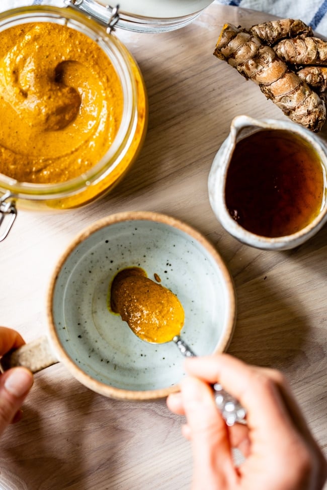 A woman is placing some of the paste in a cup