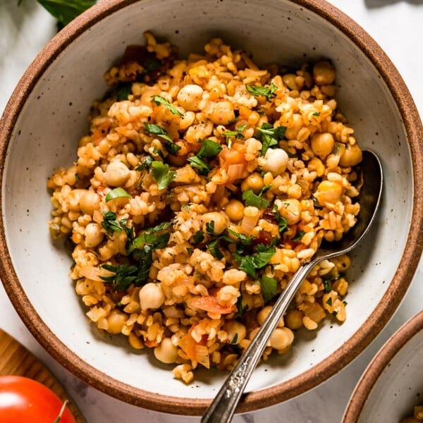 Bulgur pilaf in a bowl with a spoon on the side from top view