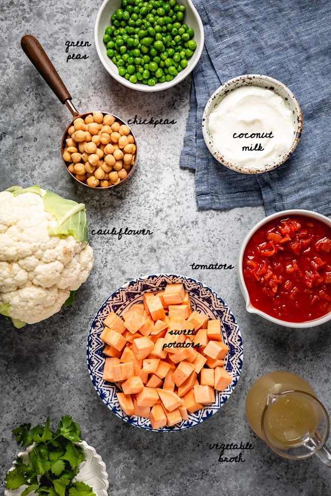 Cauliflower curry bowl Ingredients for the curry dish are placed in bowls and photographed from the top view