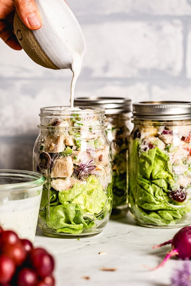 Salad in A Jar is being drizzled with the Dressing