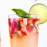 Strawberry Basil Limeade in a glass garnished with fresh basil and limes