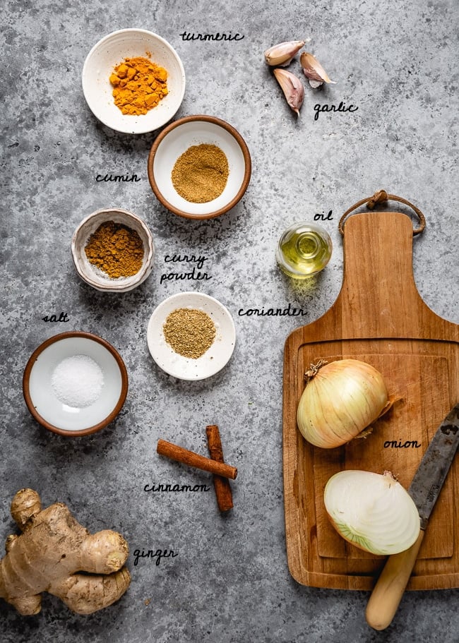 Spices, onion, and garlic for this recipe are laid out and photographed from the top view