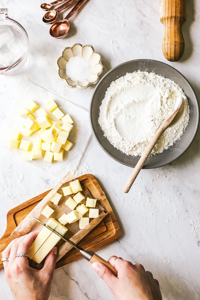 Ingredients for the easy galette dough recipe - Salt, flour, butter, and water are photographed from the top view.