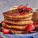 Gluten free pancakes with almond flour stacked and garnished with berries.