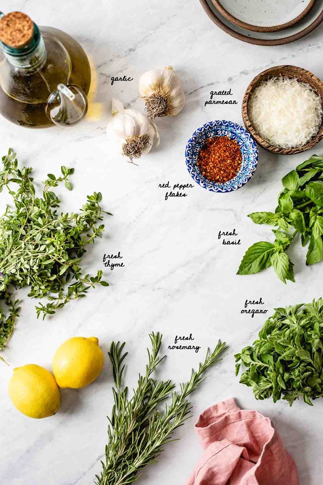Ingredients for olive oil herb dip for bread are photographed from the top view