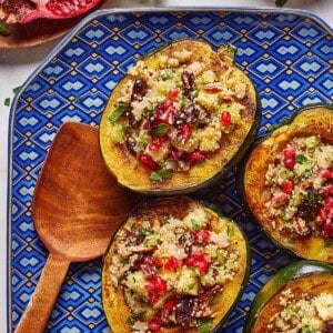 Quinoa stuffed acorn squash garnished with pomegranate seeds.