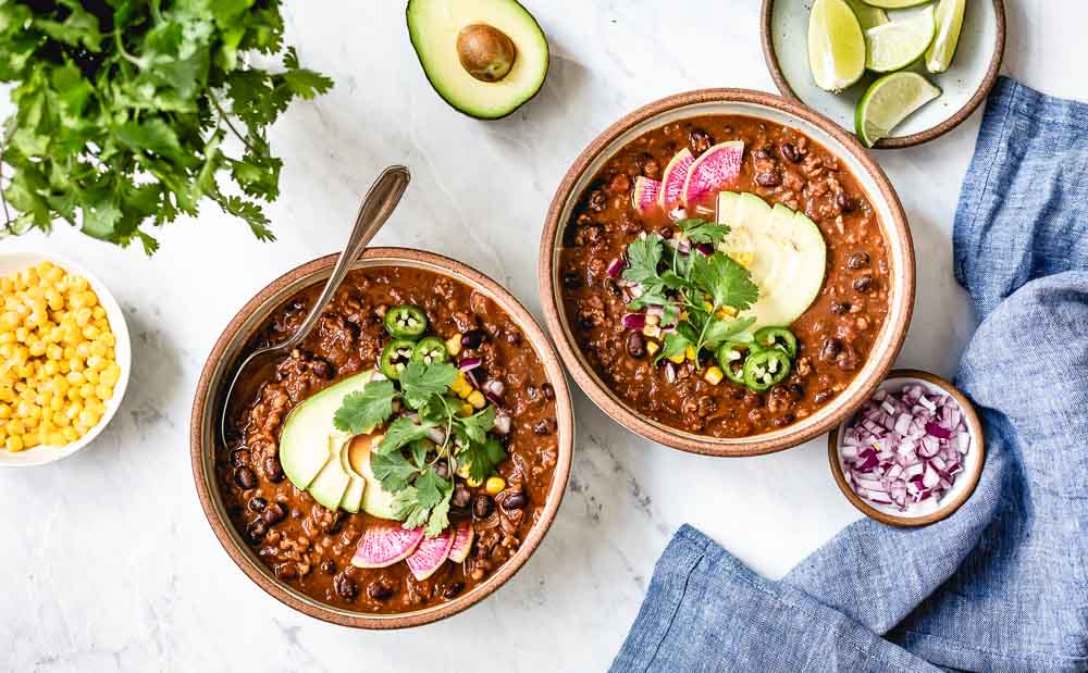 Vegan chili bowls with garnishes on the side