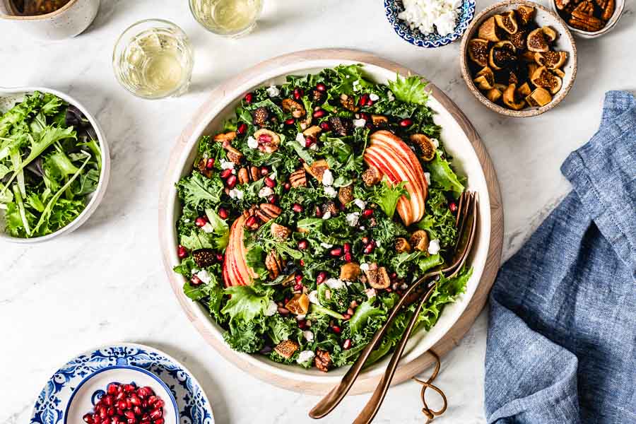 Winter Harvest Salad recipe photographed from the top view with figs, goat cheese, and pecans around it.