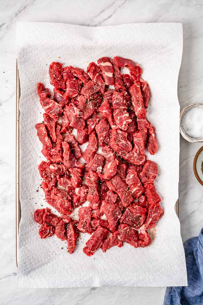 Best cut of meat, sirloin steak tips are photographed from the top view on a paper towel lined sheet pan to try them.
