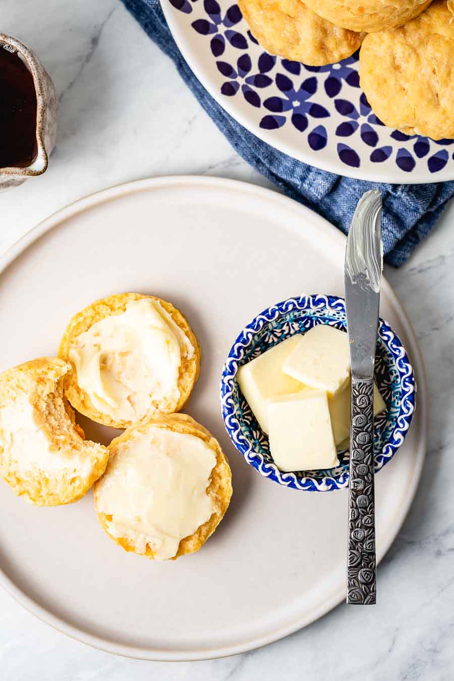 Sweet potato biscuits are spread with butter and photographed from the top view.