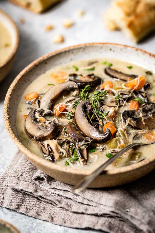 Instant Pot Chicken Wild rice soup placed in a bowl garnished with fresh thyme and photographed from the front view