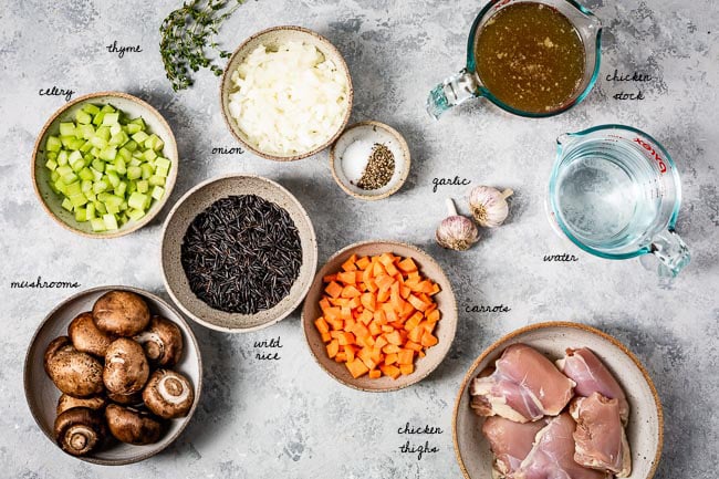 Ingredients for pressure cooker chicken wild rice soup laid out on a table and photographed from the top view.