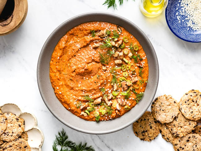 A bowl of the dip is served with crackers on the side