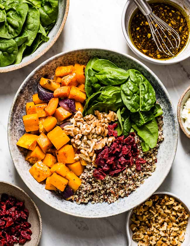 Butternut Squash Cranberry Quinoa Salad photographed from the top view with ingredients on the side