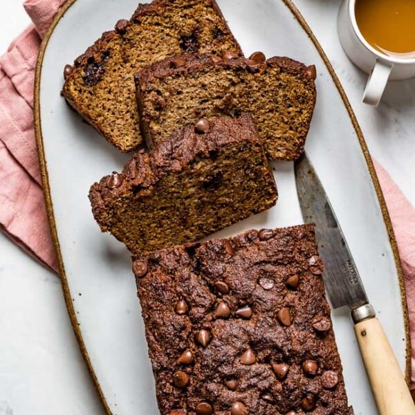 A few slices of Almond Flour Banana Bread served on a plate with two cups of coffee on the side photographed from the top view