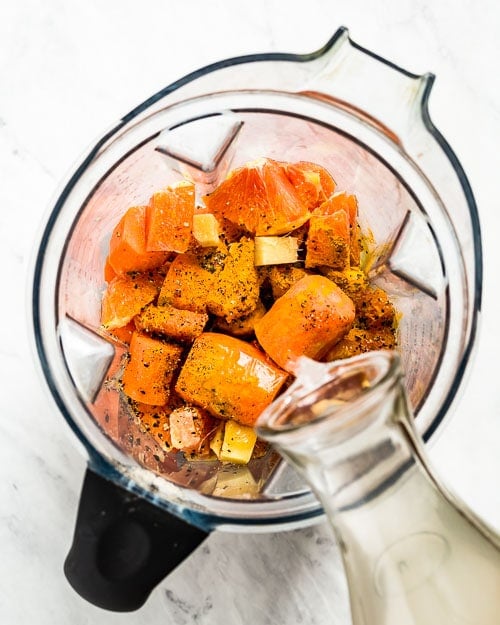 Turmeric Carrot Ginger Smoothie recipe ingredients are placed in a blender and photographed from the top view.