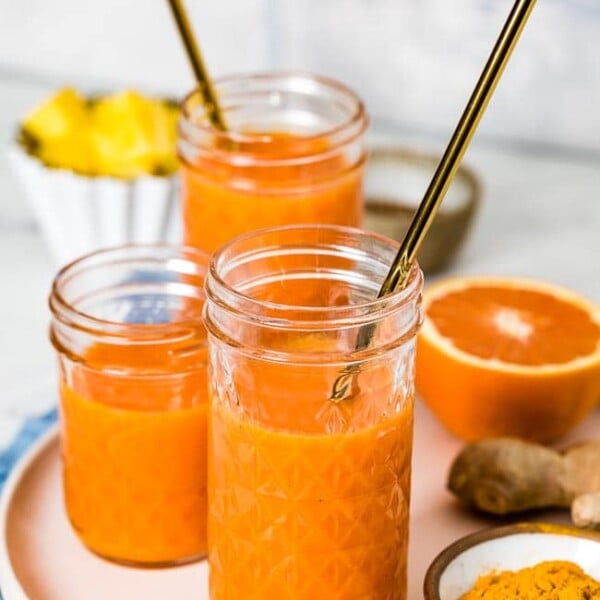 three glasses of turmeric ginger smoothie are photographed from the front view