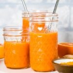 three glasses of carrot based turmeric ginger smoothie are photographed from the front view.