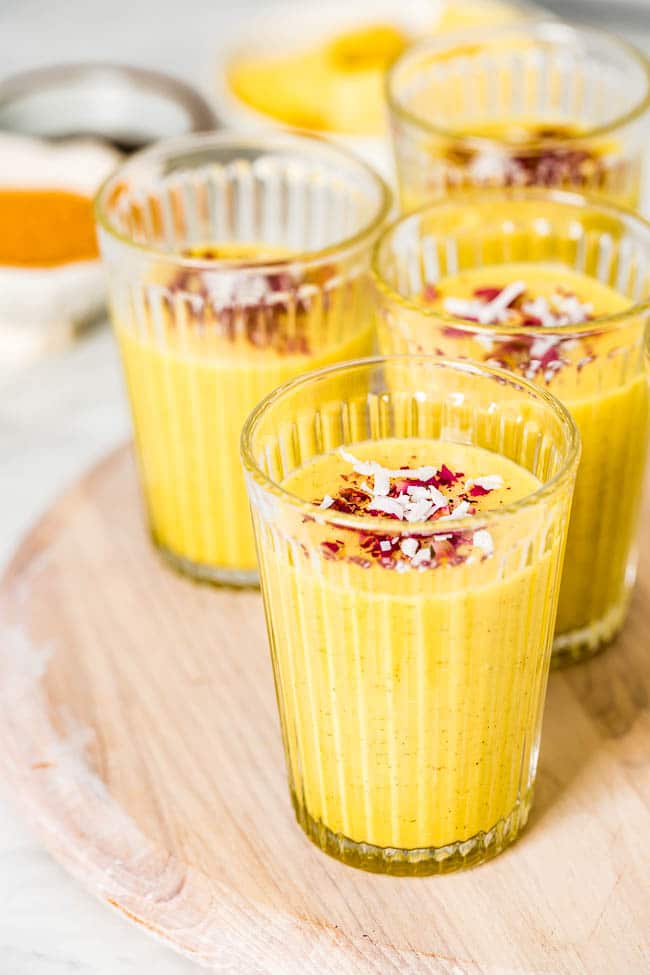 a few glasses of mango turmeric smoothie photographed from the front view.