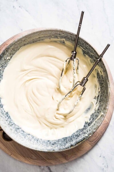 A bowl of maple cream cheese frosting with mixer legs