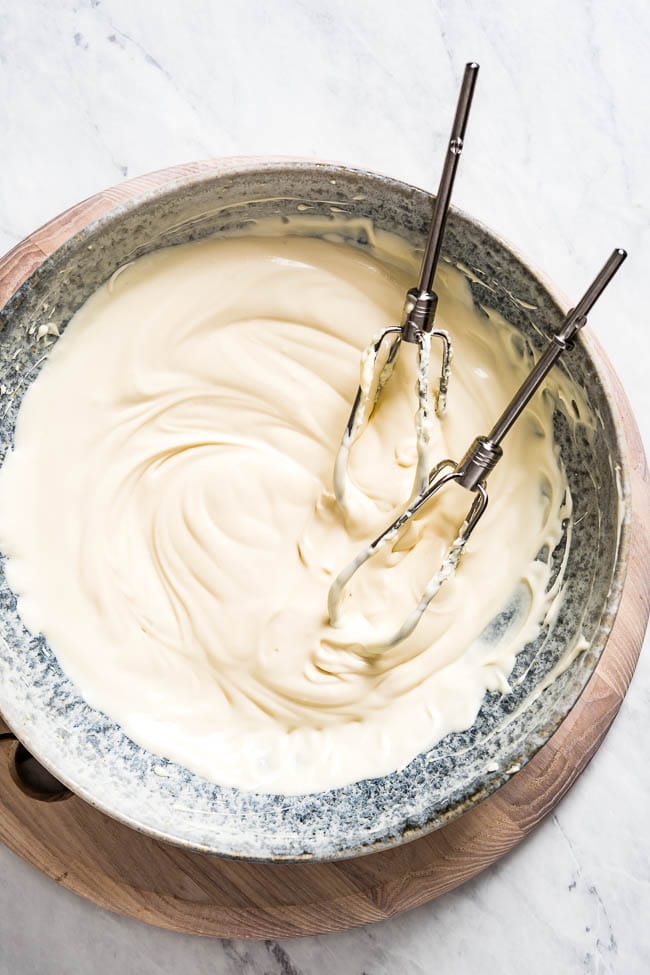 A bowl of maple cream frosting recipe is photographed on top