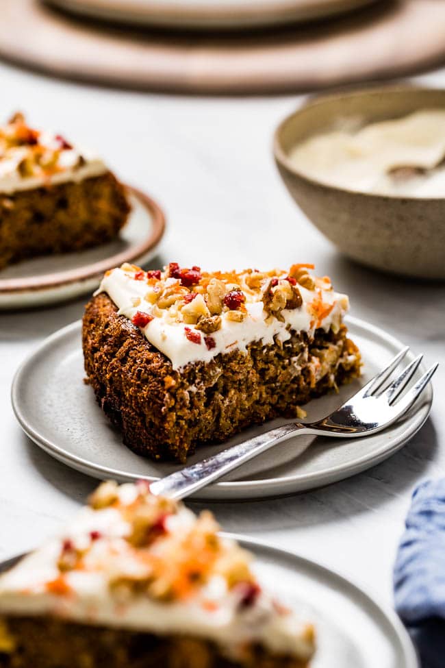 A slice Almond Flour Carrot Cake is photographed from the front view