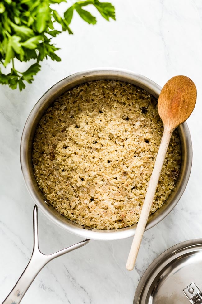 Cooked quinoa with a wooden spoon on the side