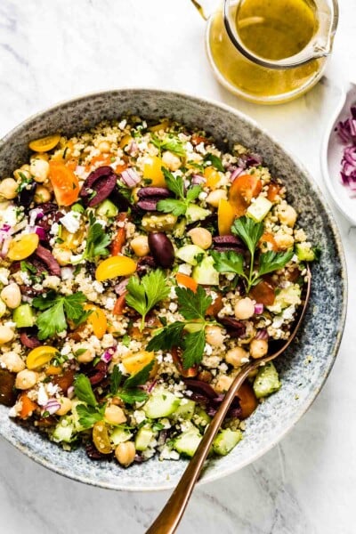 A big bowl of Mediterranean Quinoa Salad with salad dressing on the side